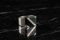 Anillo geométrico sobre mármol negro