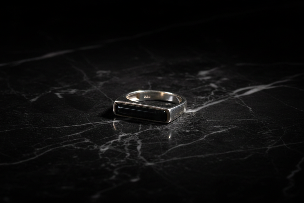 Anillo ónix rectangular sobre mármol negro