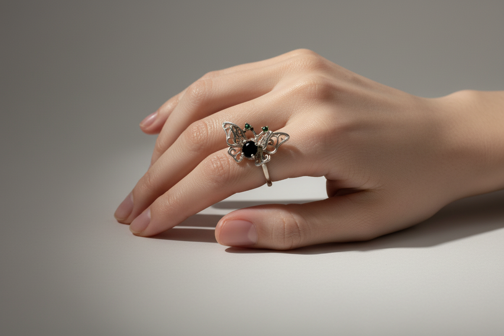 Mano femenina con anillo mariposa