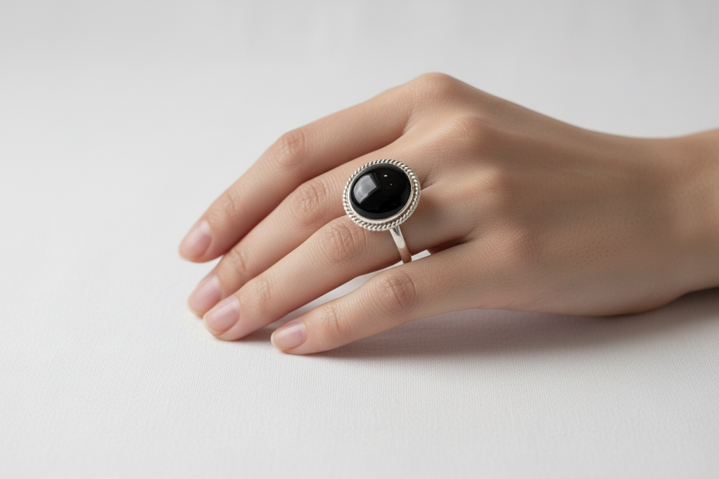Mano femenina con anillo ónix redondo